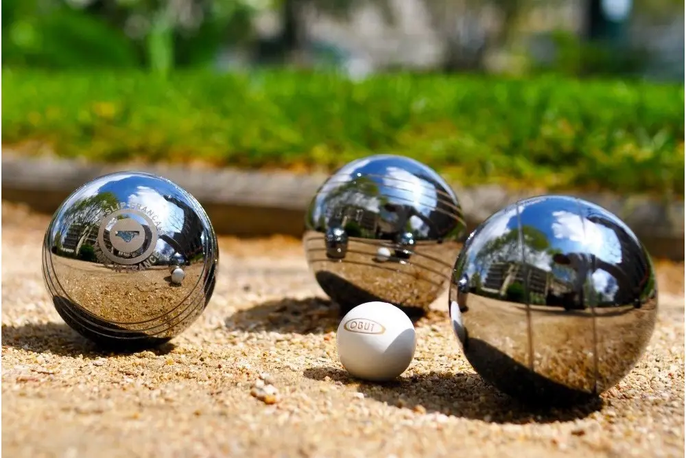 photo représentant 3 boules de pétanque accompagnées d'un cochonnet au milieu.